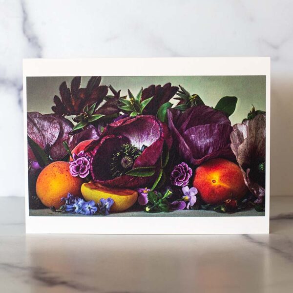 Photograph of a greeting card with purple poppies and apricots on it.