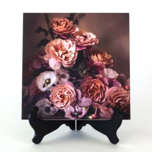 Photo of pink roses and poppies (white, purple & pink) and a honeybee printed on ceramic tile. The art piece is displayed on a black tabletop easel.