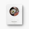 Pictured: The back of the notebook. The white background has a decorative pattern screened lightly on it. On top of the design, there is a close up of the cover image in a circle.