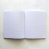 Pictured: A lay flat notebook open. Both white pages show lined pages.