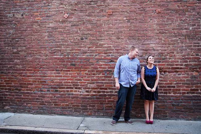 Couple standing in front of brick wall